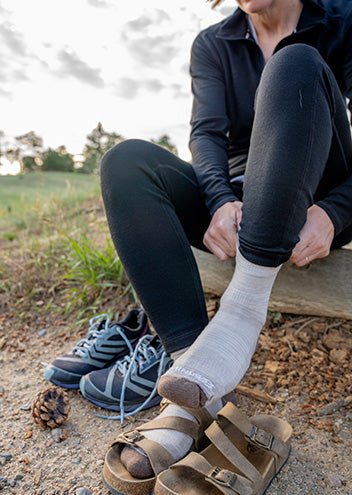 woman putting on nh usa made sock to go running