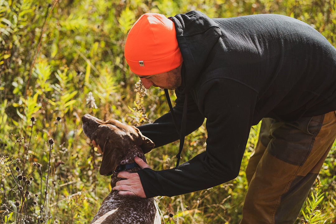 man petting his dog getting ready to go hunting wearing minus33 kodiak fleece hoodie