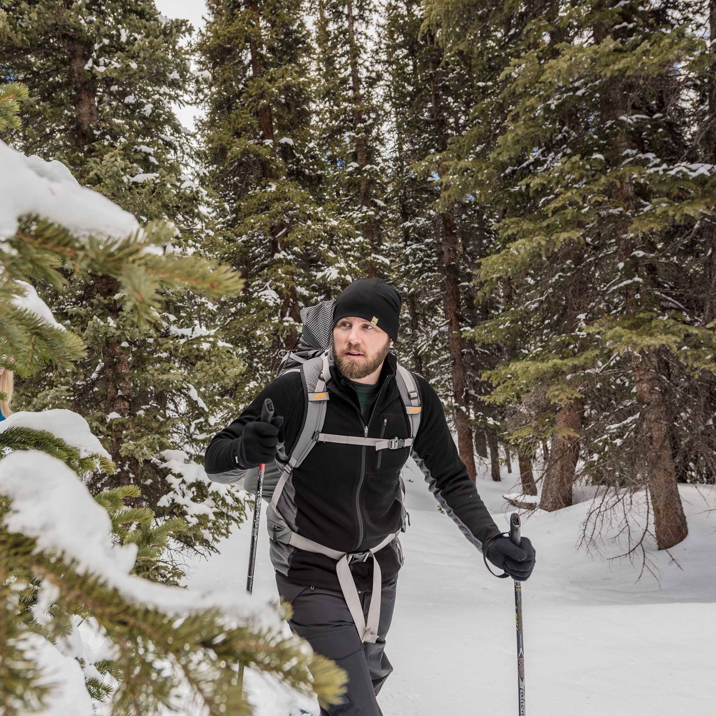 man snowshoeing with midweight layers one