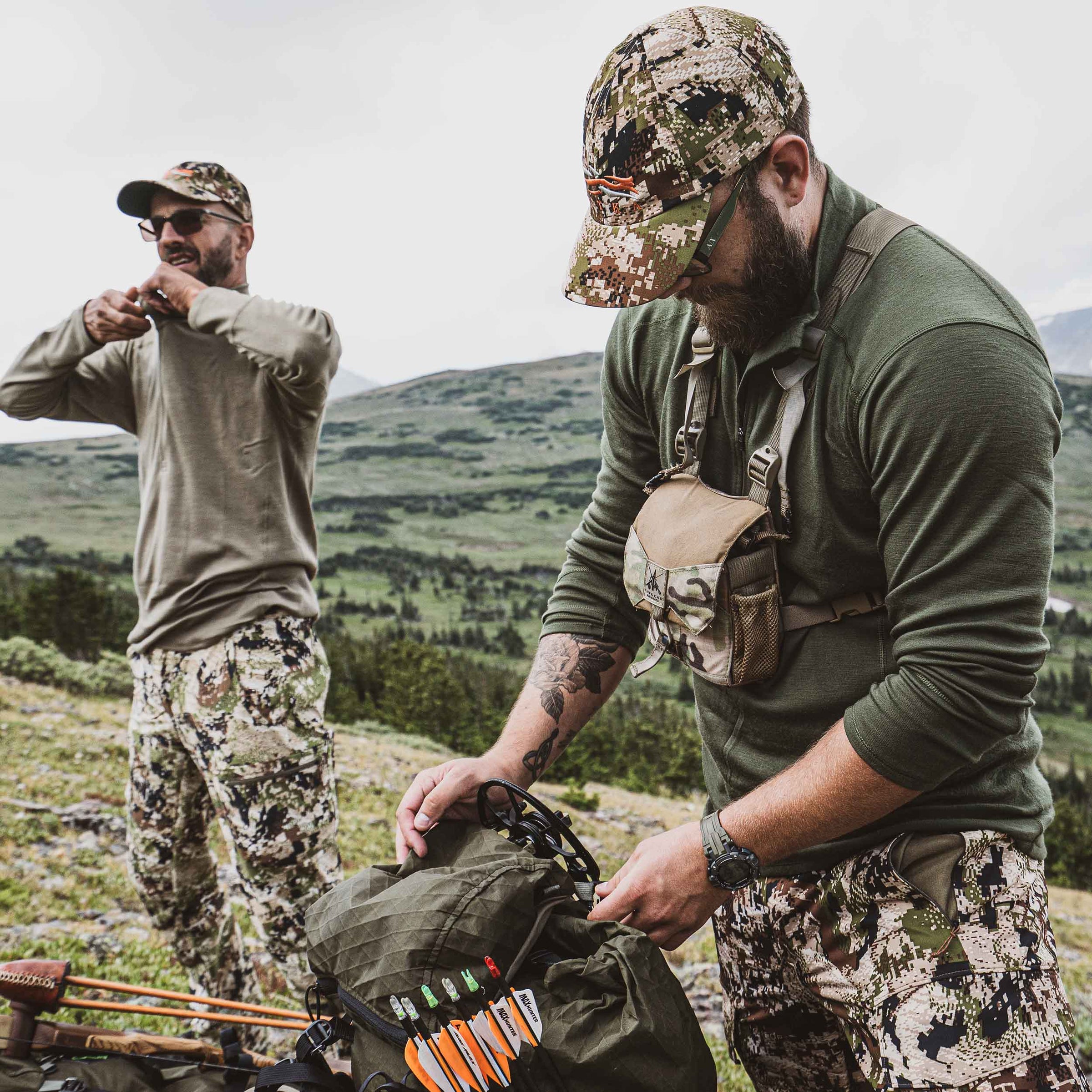 two guys wearing a midweight long sleeve shirt and 1/4zip getting ready for hunting wearing camo btu pants