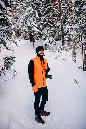 man hiking wearing blaze orange wilderness expedition vest