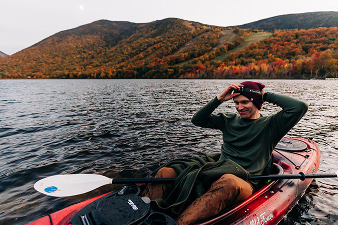 man kayaking in the fall wearing a midweight crew neck