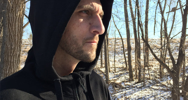 minus 33 merino wool clothing, 50 campfires reviews the Kodiak Expedition hoody. close up of man wearing the hood in the woods.