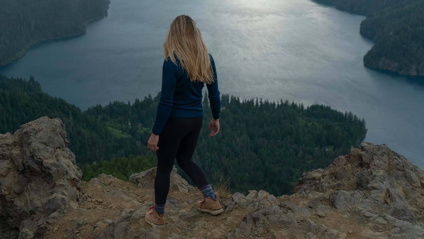 woman hiking while wearing minus33 merino wool midweight base layer crew top