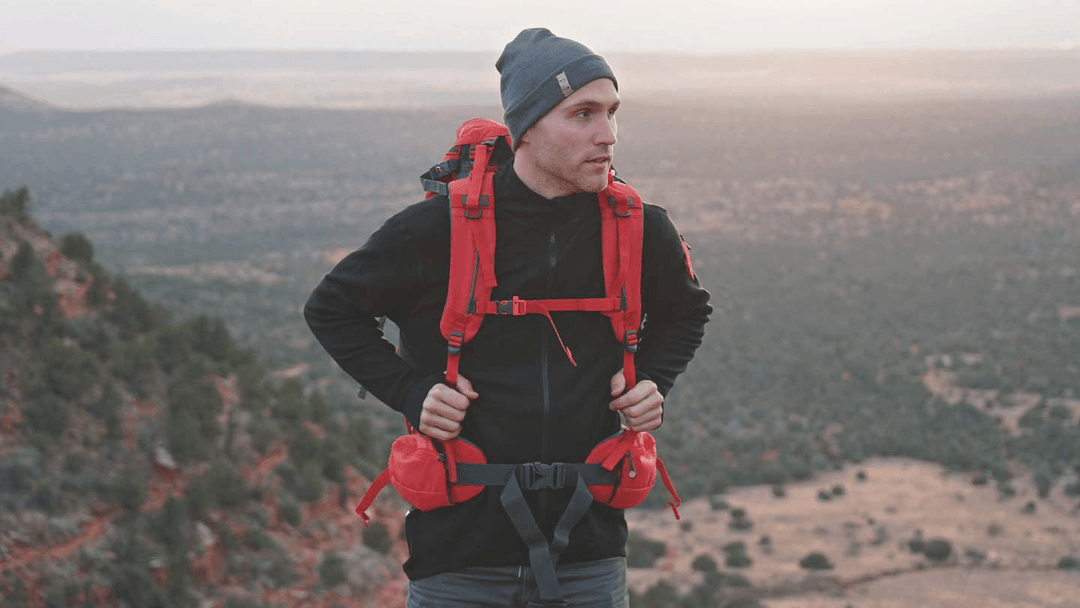 man hiking in arizona while wearing minus33 merino wool mid layer shirt and beanie