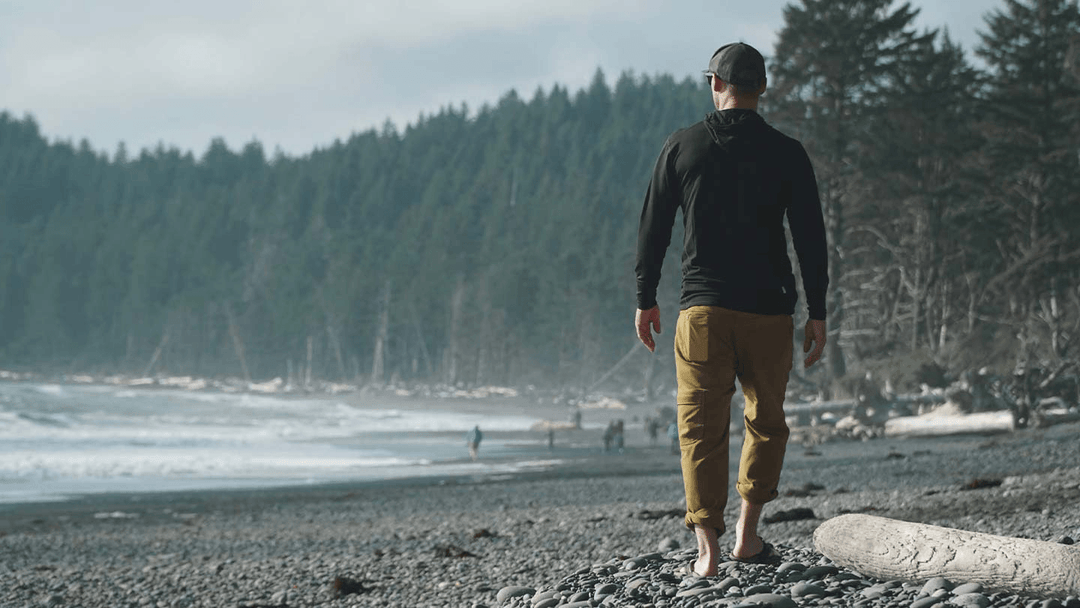 man walking on beach in casual pants and minus33 merino wool micro hoodie