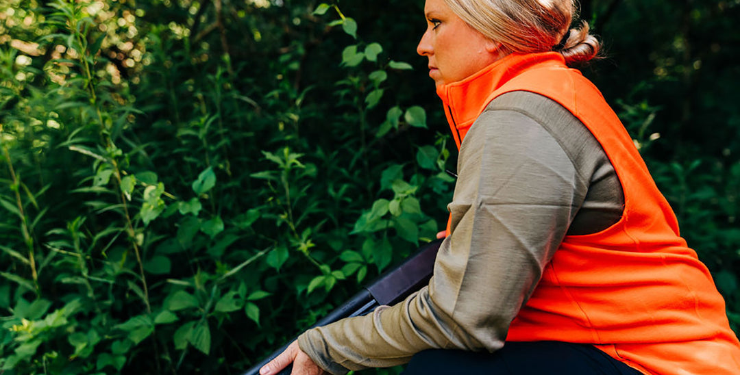 woman hunting wearing blaze orange vest 