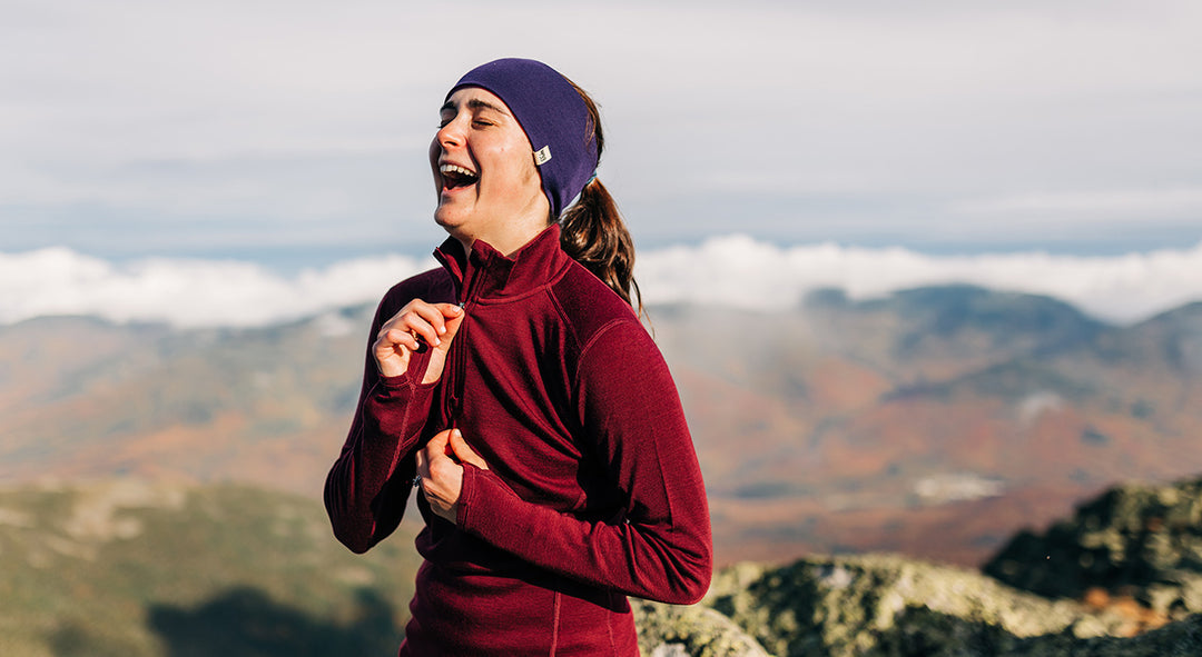 woman hiking in the fall wearing midweight base layers and reversible headband