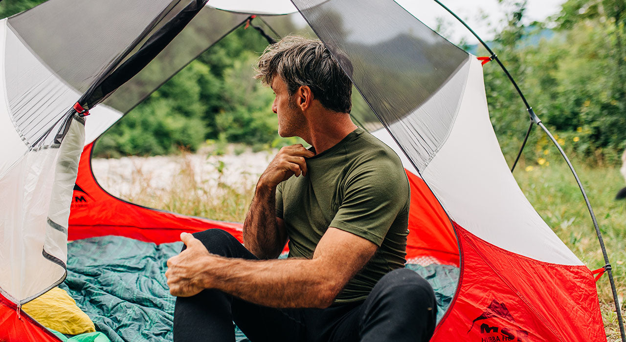 man camping wearing micro weight woolverino merino wool  olive drab raglan tshirt