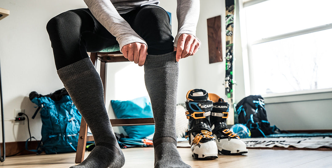 Man getting ready to ski with 3/4 bottoms and ski socks