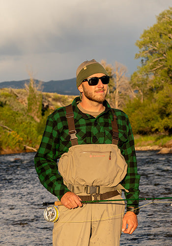 man fishing wearing green buffalo plaid sportsman shirt with reversible beanie