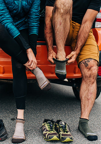 No show running socks. Male and female putting on socks about to go for a run sitting in the trunk of a car