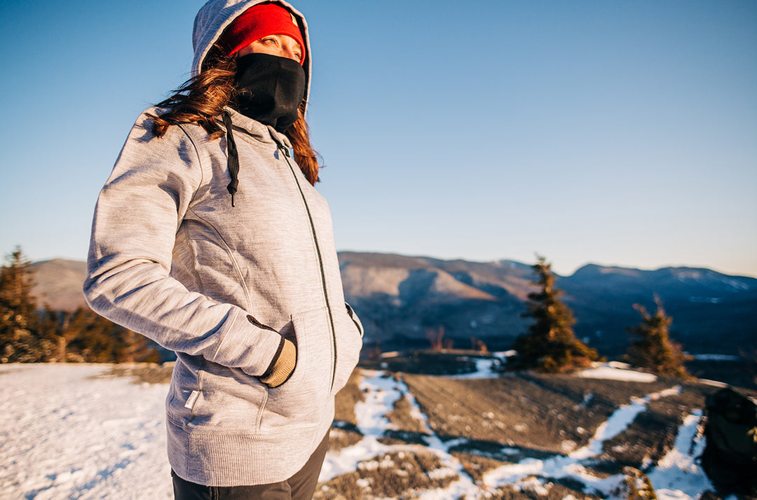 woman wearing merino wool heavyweight kodiak fleece expedition sweatshirt ontop of mountain with snow