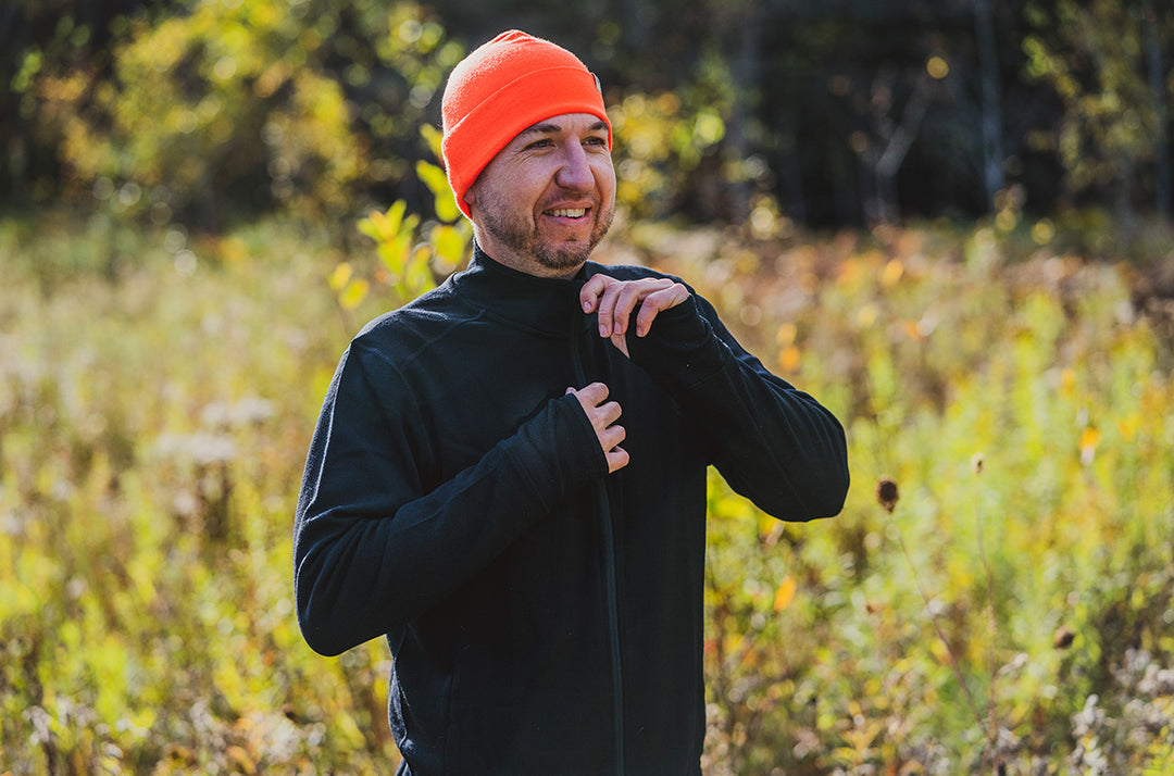man hunting wearing merino wool blaze orange beanie and wool wilderness mid layer