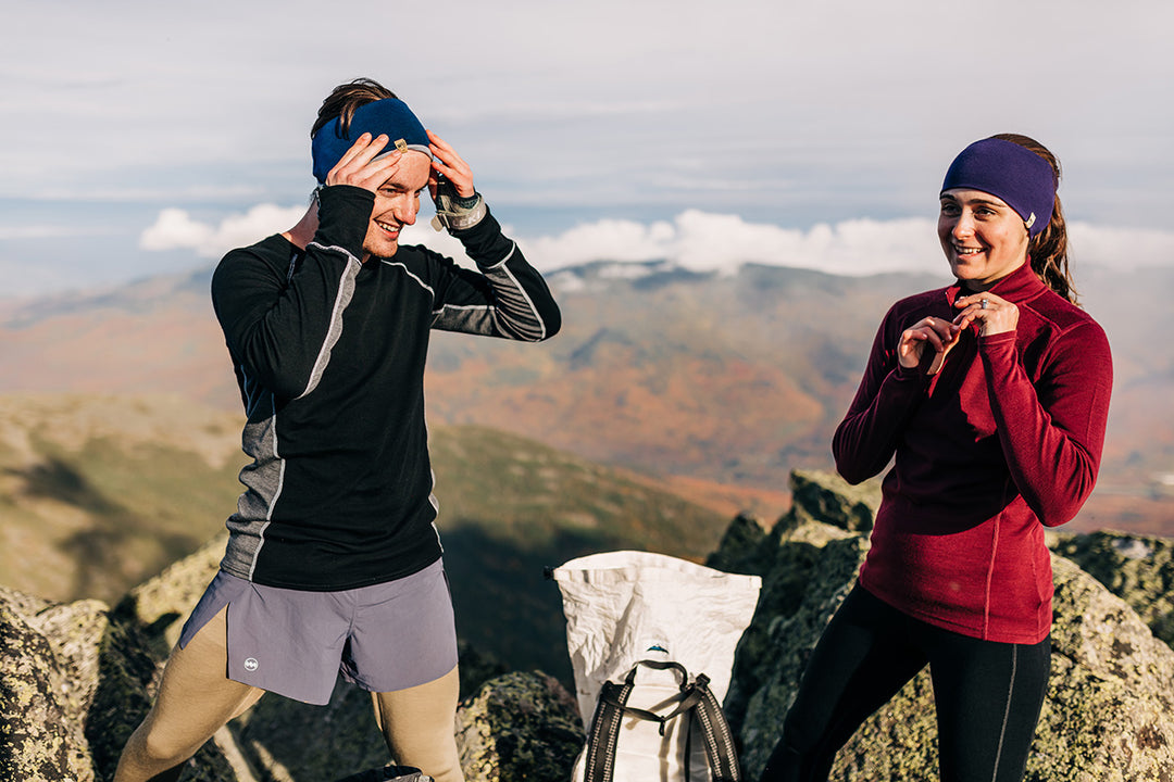 man and woman hiking while wearing a woolverino midweight top in mens and a womens woolverino midweight bottoms